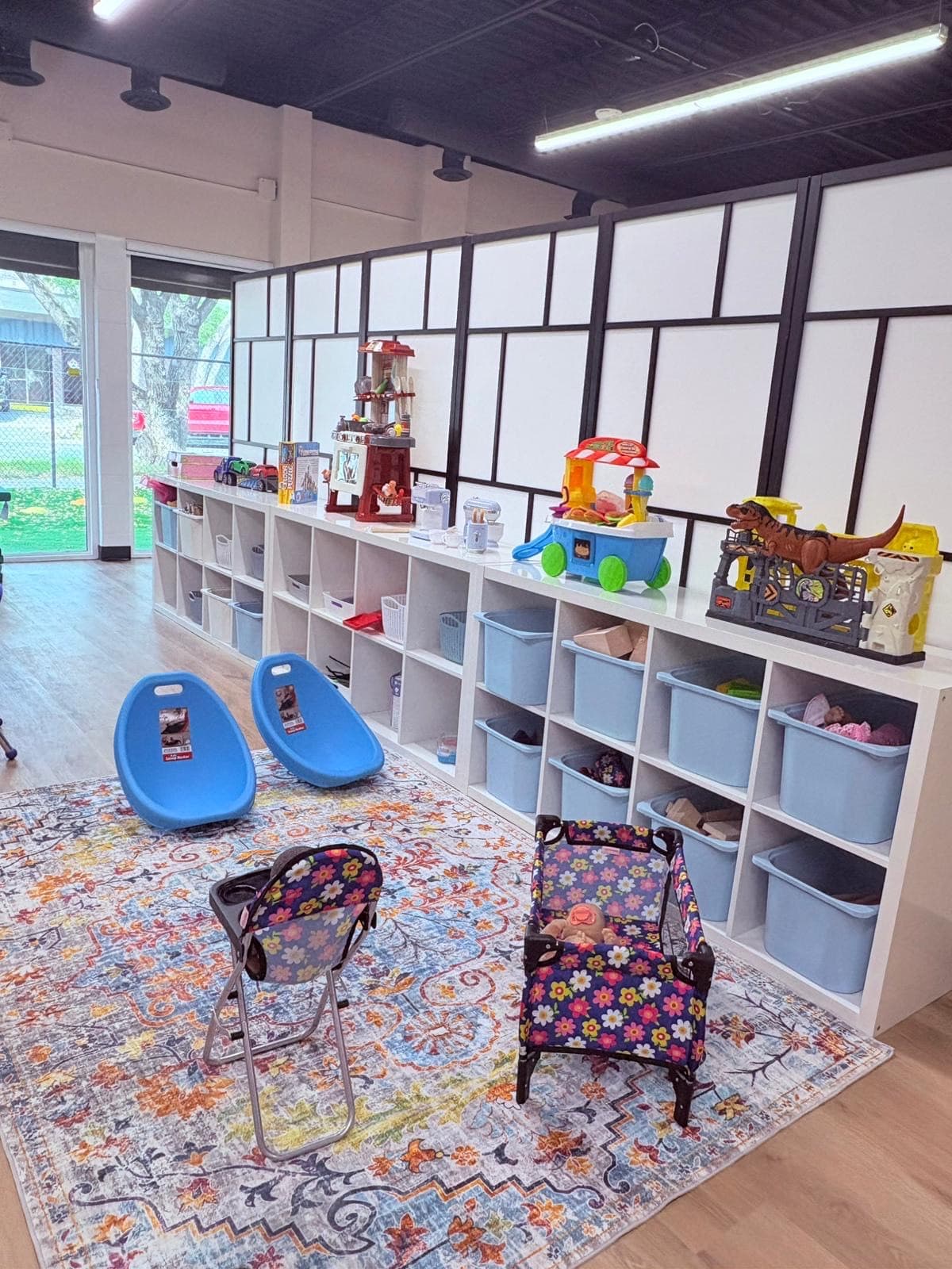Large classroom with cubbies and colorful dramatic play area